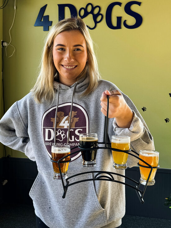 Woman Bartender holding a flight of beers